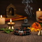 Karungali Rudraksha Damru Bracelet in a spiritual Indian setting with diya, bilva leaves, marigold flowers and Shiva lingam