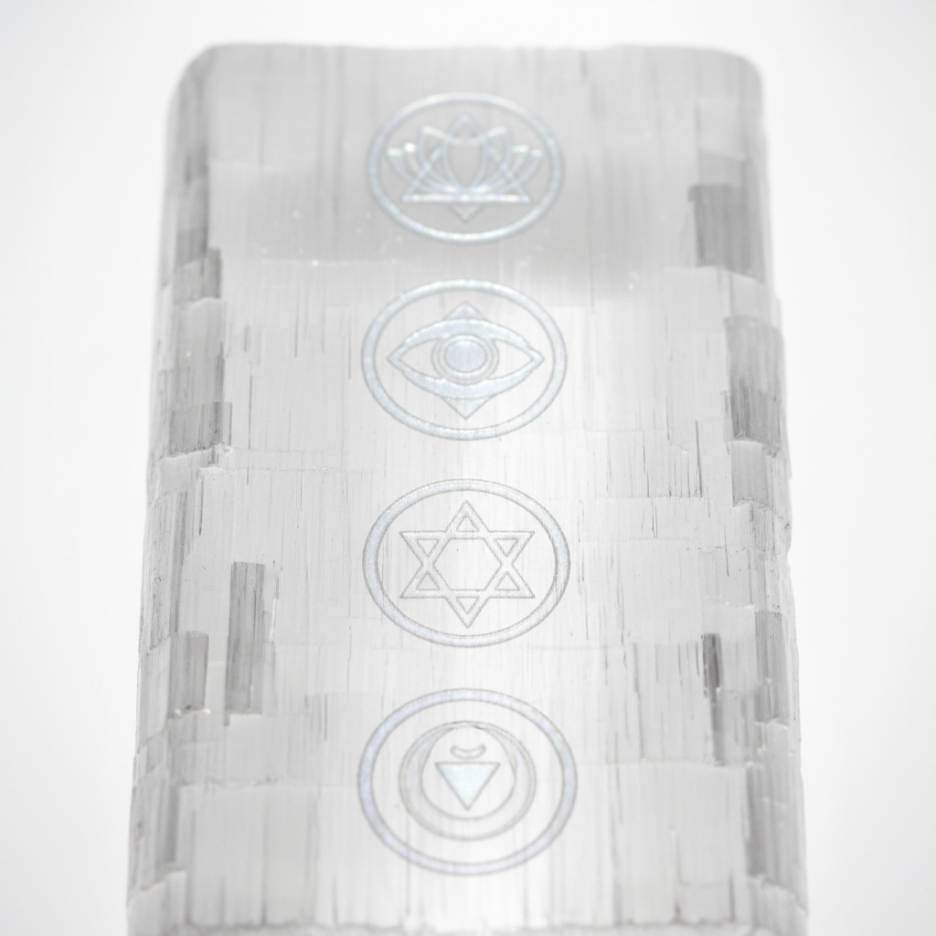 7 Chakra Selenite Plate macro close-up showing engraved chakra symbols and natural fibrous white selenite texture